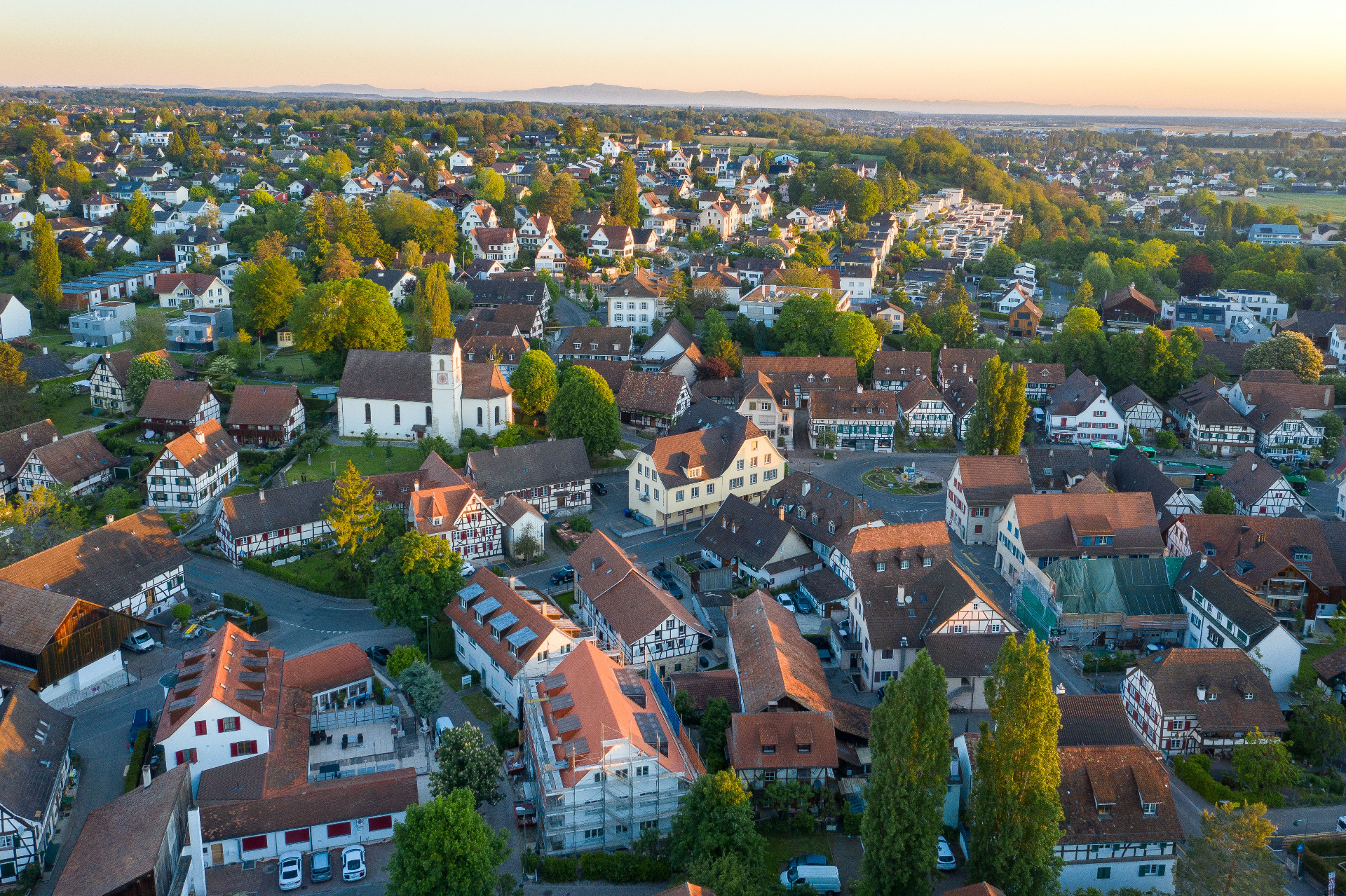 Luftaufnahme von der Gemeinde Allschwil mit dem alten Dorfkern im Vordergrund. 